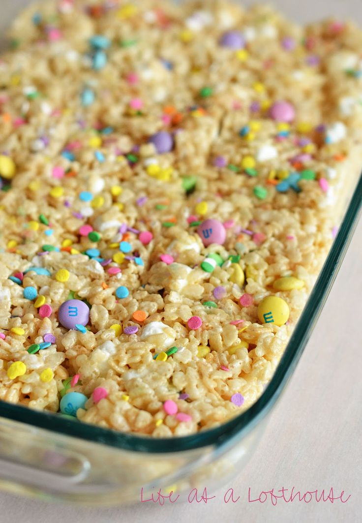 rice krispy treats in a glass dish with sprinkles and colored candies