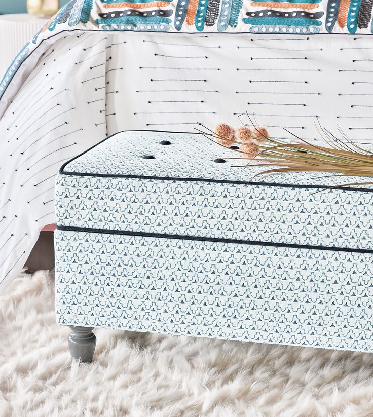 an upholstered mattress sits on top of a white rug in front of a bed