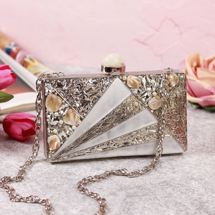 Keep it elegant but contemporary by adding a little sass to your look. This beautiful statement piece is a must-have. All our clutches are handcrafted and these very unique pieces! Comes with a Detachable chain strap All of our premium products include luxury gift boxes. Dimensions : 19 cm x 15 cm x 4 cm (L x W x H) Material Metal Water Resistant Not Water Resistant Pattern Embellished/Sequined Handle Yes Compartment Yes Pockets Yes Dimensions 19 cm x 15 cm x 4 cm (L x W x H) Care Instructions Clean And Care: Dust Off Or Wipe The Stains Immediately With A Slightly Damp, Lint-free Cloth. Do Not Use Any Hard Scrubber Or Brush. Pack Contains 1 Clutch Pearl Clutch Bag, Unique Clutch, Pearl Clutch, Crystal Clutch, Bridal Clutch, Beaded Bag, Wedding Bag, Handmade Bag, Coral Beads