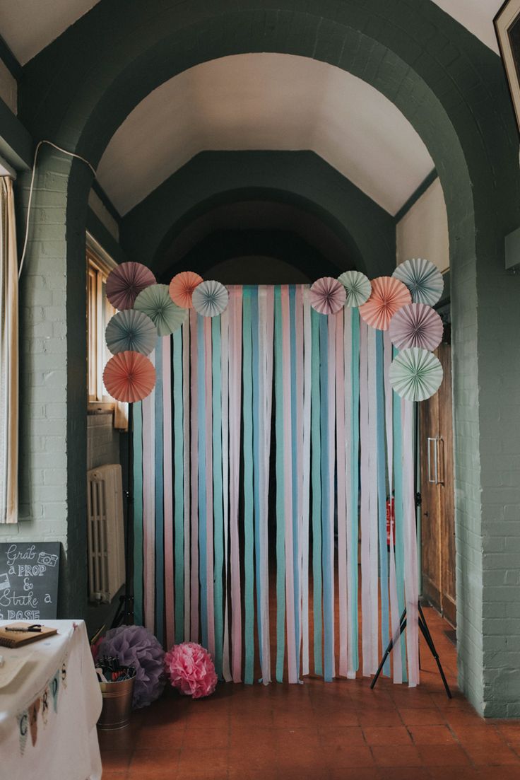 the backdrop is decorated with paper flowers and umbrellas