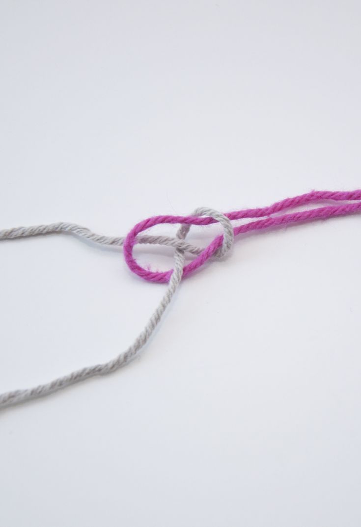 the pink and gray string is attached to the white cord on the left side of the photo