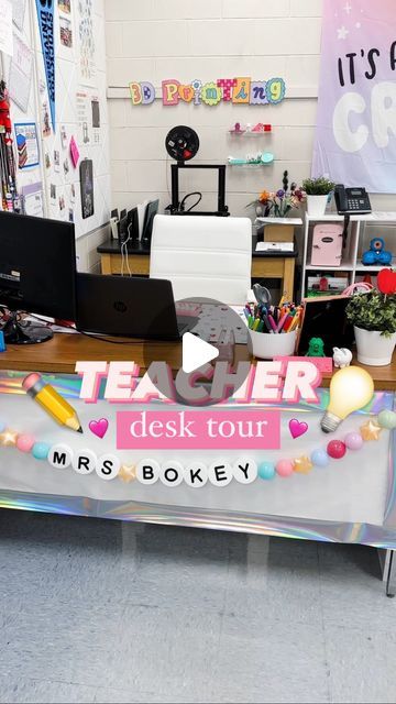 a desk with a teacher's desk tour sign on it in front of a classroom