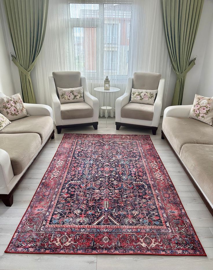 a living room with two couches and a rug in front of a window on the floor