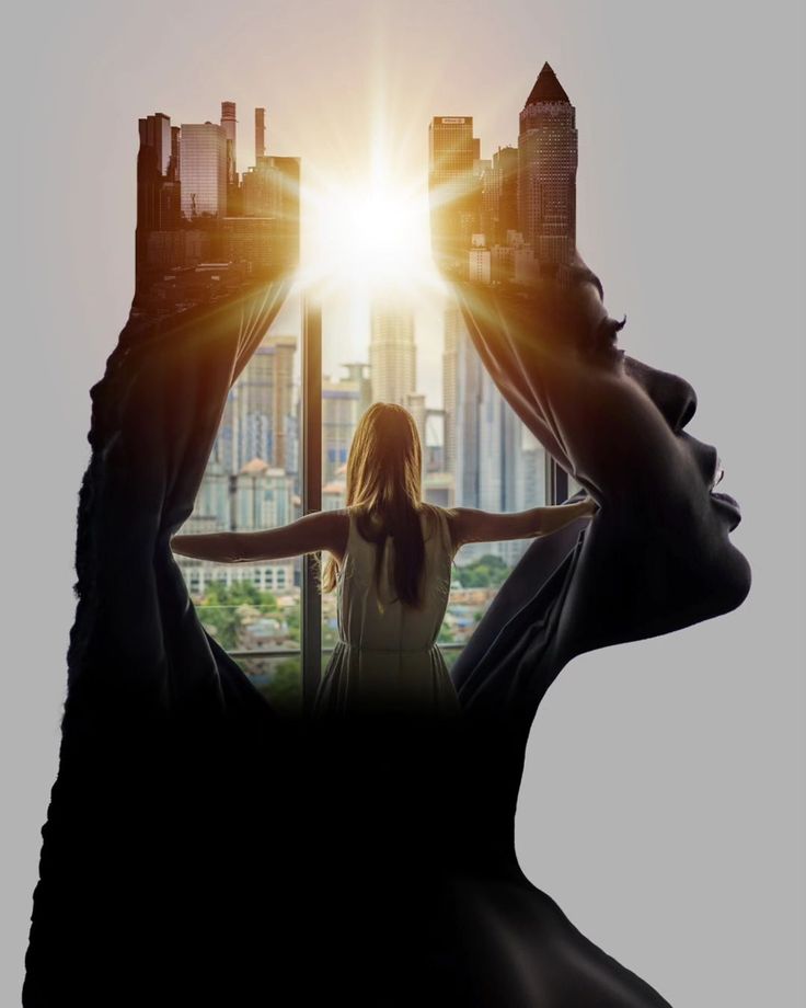 a woman standing in front of a window with the sun shining through her head and buildings behind her