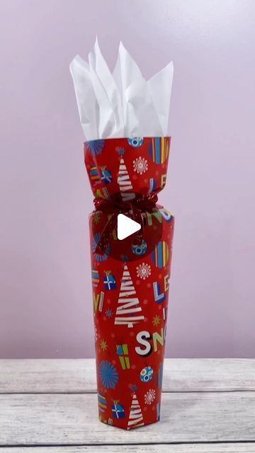 a red wrapped gift with white tissue paper on it and the words santa written in large letters