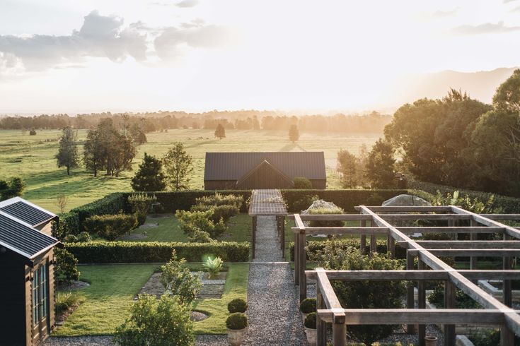 an aerial view of a house and garden at sunset