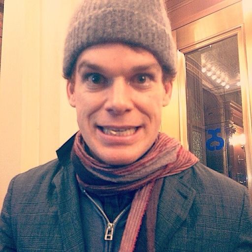 a man wearing a hat and scarf in front of an elevator door with his mouth open