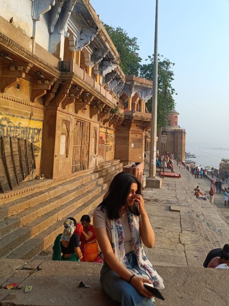 a woman sitting on the ground talking on her cell phone