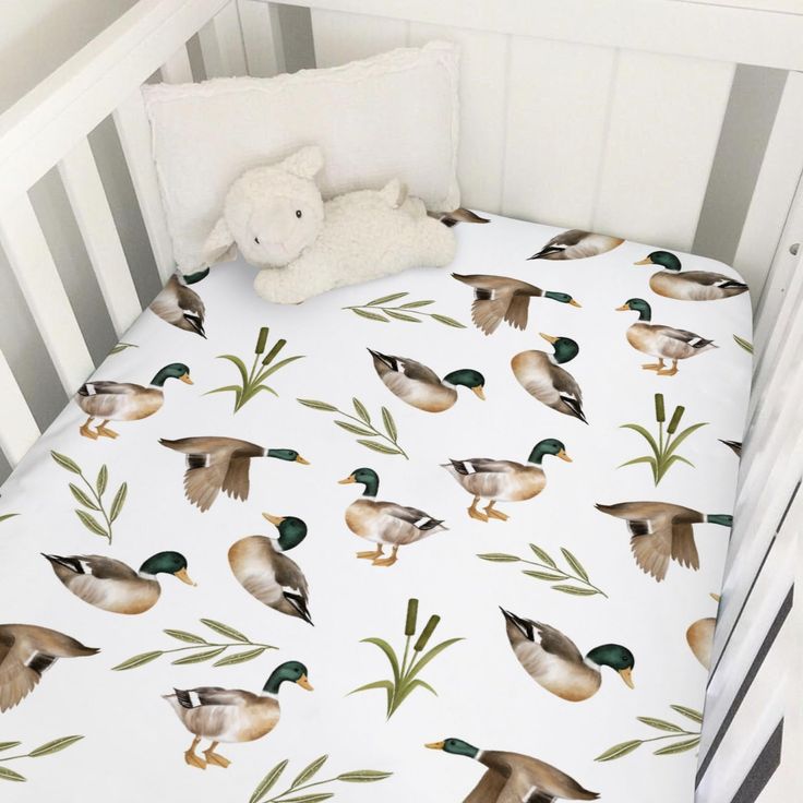 a white crib bed with ducks on it