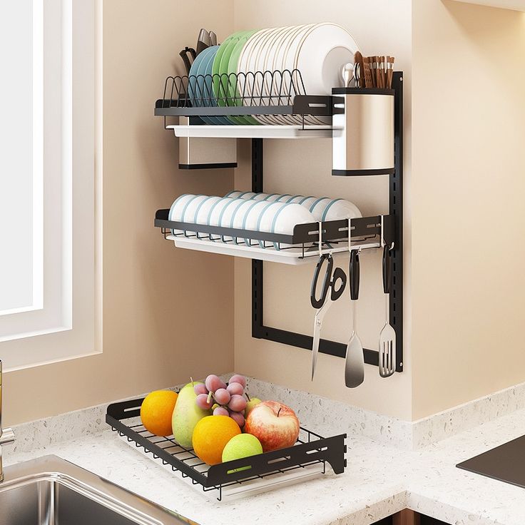 a dish rack with plates and utensils hanging on the wall next to a sink