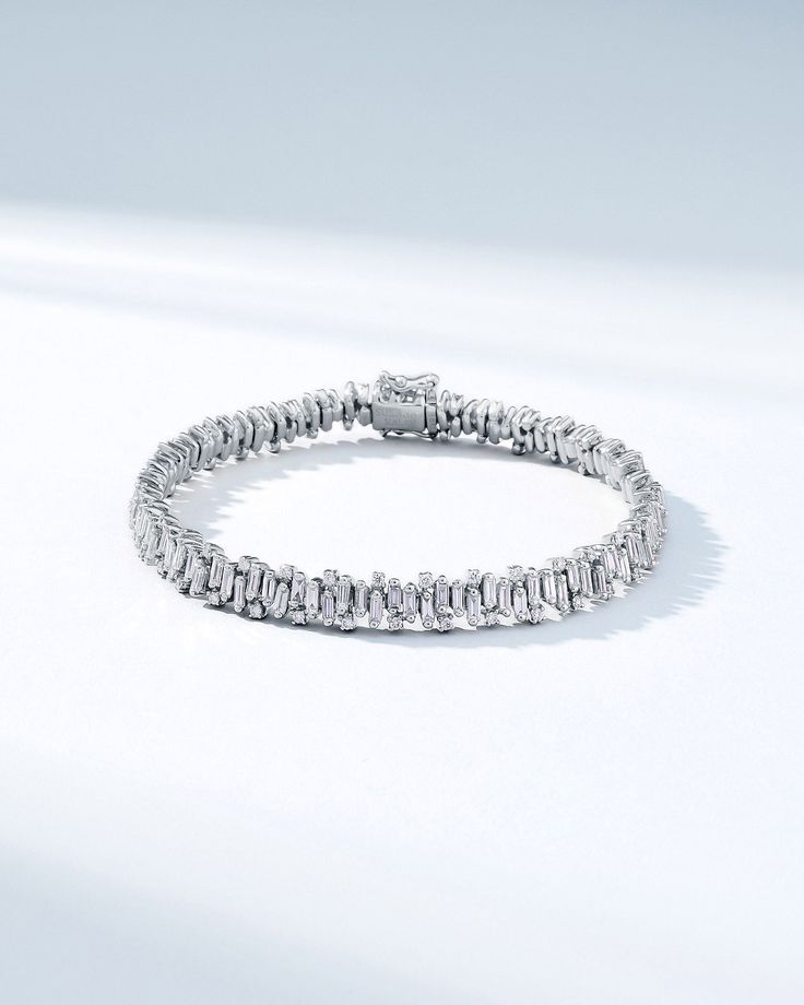 Handcrafted in 18-karat gold, this bracelet features an artfully organized array of vertically stacked baguette diamonds, alternating with round white diamonds, creating in a stunning statement piece. Set with 6.51 carats of white diamonds, this bracelet is crafted to capture light and attention, ensuring it sparkles brilliantly on your wrist. Details 18k yellow gold, rose gold or white gold 6.51 carats of baguette and round white diamonds Bracelet measures 7" inches in length Box clasp with saf Silver Round Diamond Bracelet With Baguette Diamonds, Luxury Platinum Diamond Bracelet With Baguette Diamonds, Luxury Baguette-cut Diamond Bracelet With 17 Jewels, Luxury White Gold Tennis Bracelet With Baguette Diamonds, Elegant Platinum Bracelet With Baguette Diamonds, Elegant Platinum Diamond Bracelet With Baguette Stones, Luxury Diamond Tennis Bracelet With Baguette Cut, Elegant Platinum Diamond Bracelet With Baguette Diamonds, Diamond White Platinum Bracelet With Baguette Diamonds