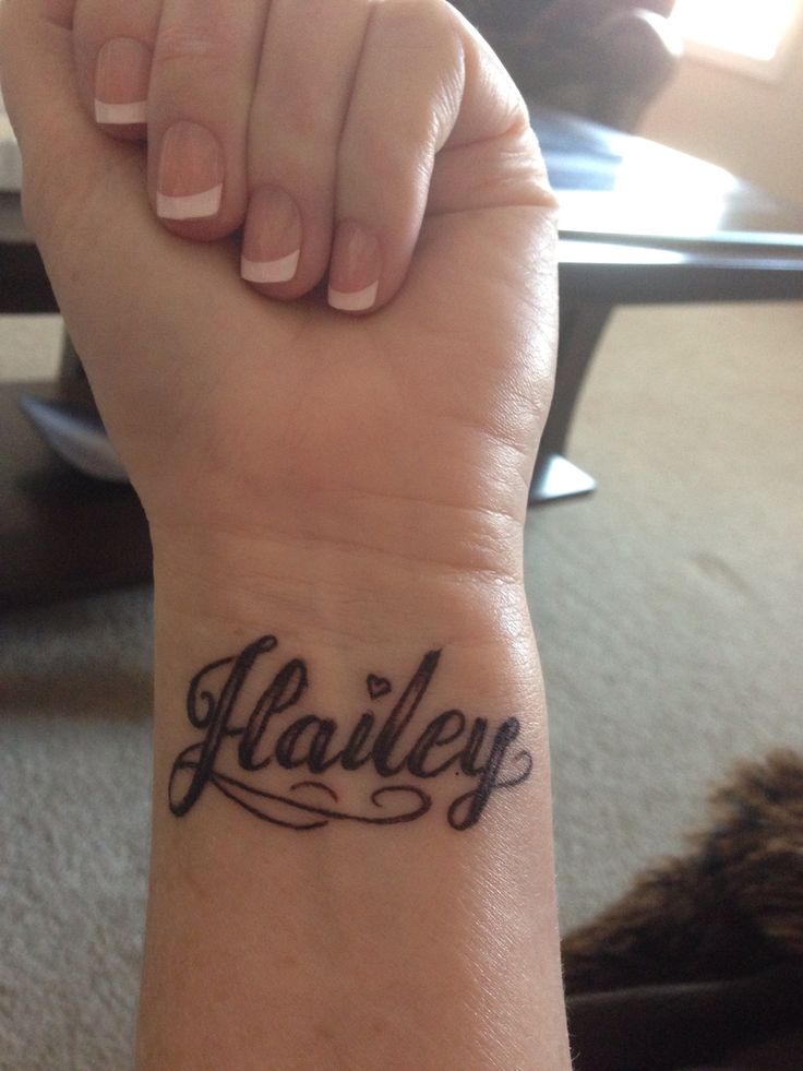 a woman's wrist tattoo with the word harley written on her left arm and in cursive font