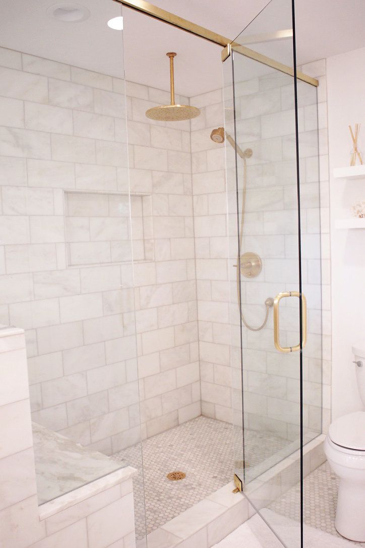 a white toilet sitting next to a walk in shower