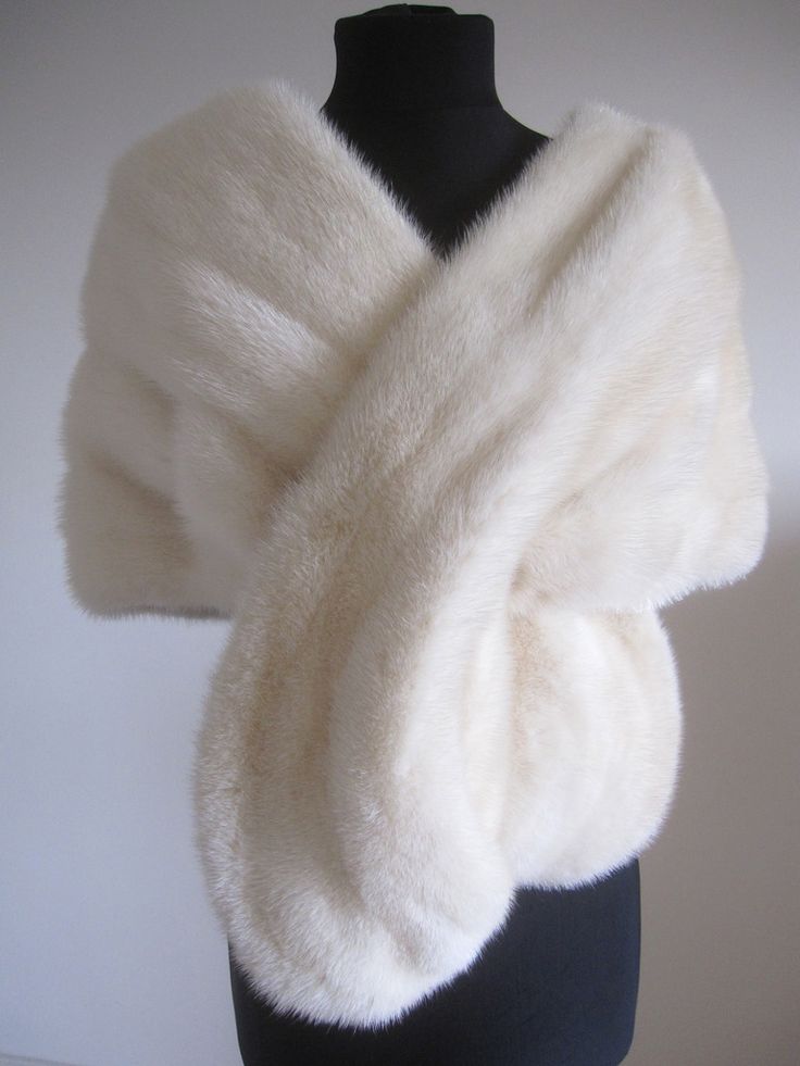 a white fur shawl draped over a black mannequin