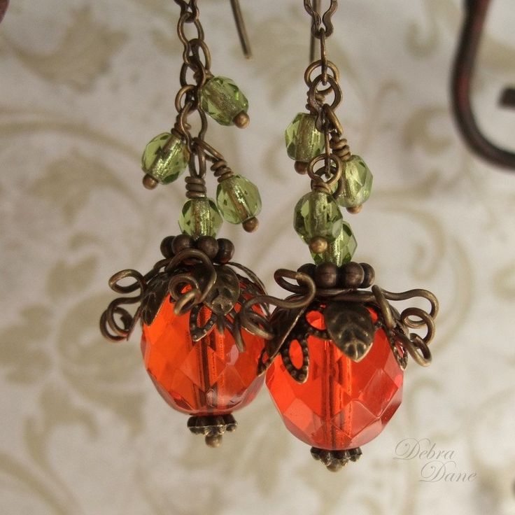 "A new twist to my original designthese adorable little pumpkins in spicy orange, faceted glass beads, dangle from a sparkly vine of tiny glass beads in peridot green. Still crowned in layers of antiqued brass leaves and curlycues vines these little pumpkins are perfect for that person wanting just a little bit more spice! Length from bottom loop of french earwire: 1.5\"(33mm) Prefer a different style of earwires? Non pierced clips as well as leverbacks are also available for no extra charge. Pl Orange Faceted Beads Dangle Earrings, Orange Faceted Beaded Earrings For Gift, Vine Earrings, Pumpkin Vine, Pumpkin Earrings, Orange Earrings, Peridot Green, Orange Pumpkin, Pretty Box