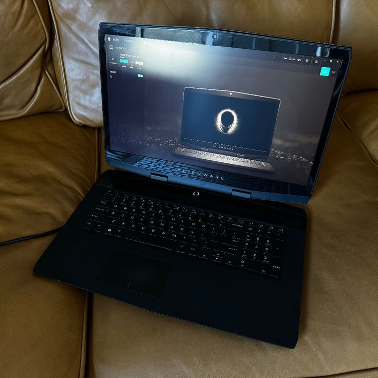 an open laptop computer sitting on top of a couch