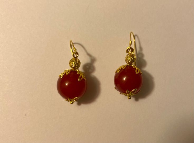 Beautiful, handmade, red-dyed jade earrings with a delicate golden leaf surrounding and nickel-free ear wire. Handmade Red Earrings For Formal Occasions, Red Carnelian Pierced Earrings, Gold Carnelian Earrings With Ear Wire, Carnelian Gold Earrings With Ear Wire, Handmade Red Ruby Earrings, Gold Carnelian Dangle Earrings, Red Carnelian Earrings With Ear Wire, Red Carnelian Teardrop Earrings, Carnelian Round Earrings With Ear Wire