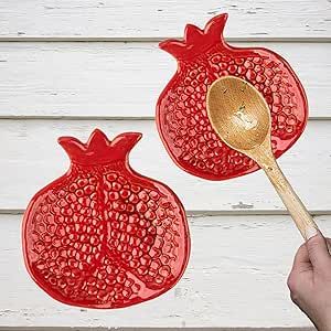 two red pomegranates cut out with a wooden spoon