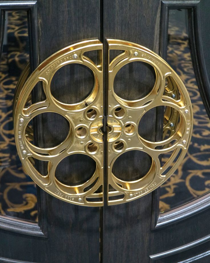 a close up of a door with gold circles on it's side and an ornate design