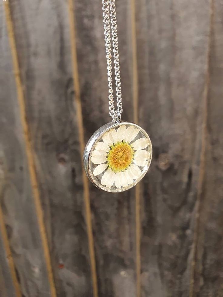 *Beautiful handcrafted real daisy necklace set in resin. *Add some spring sunshine to an outfit *Pendant is resin with a real daisy set inside April birth flower  *Pendant is 28mm x 28mm *Chain is 18 inches and gold plated for gold pendant and silver plated for silver pendant Please let me know if you require a different length chain. *Jewellery care* Please do not shower or sleep with this necklace on and avoid harsh chemicals. Please contact me with any enquiries and thank you for looking at my page Daisy Resin Necklace, Everyday Flower Necklace With Flower Charm, Cute Flower Necklace With Flower Charm, White Flower-shaped Jewelry With Sunflower Design, White Flower Jewelry With Sunflower Design, White Sunflower Design Flower Jewelry, Cute Flower Necklace As A Gift, Adjustable Round Flower Charm Necklace, Cute Flower Shaped Necklace For Gift