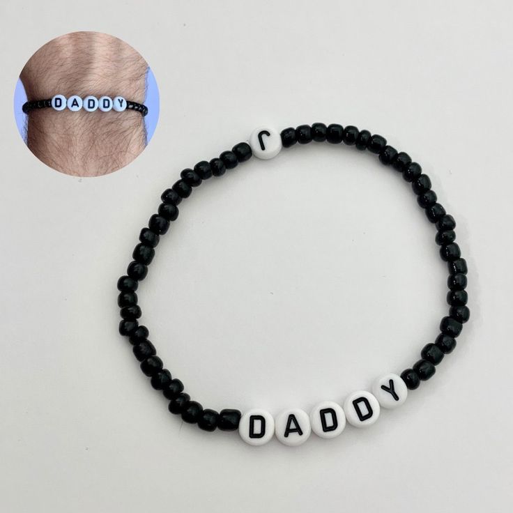 a black beaded bracelet with the word daddy written on it and an image of a man's head