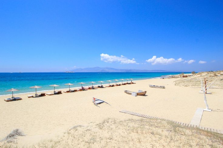 an empty beach with umbrellas and chairs on it