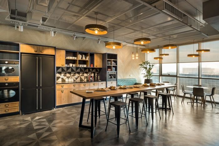 a large kitchen with lots of counter space and chairs around the table in front of an open window