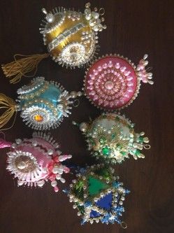 several different types of brooches sitting on a table next to each other with tassels around them