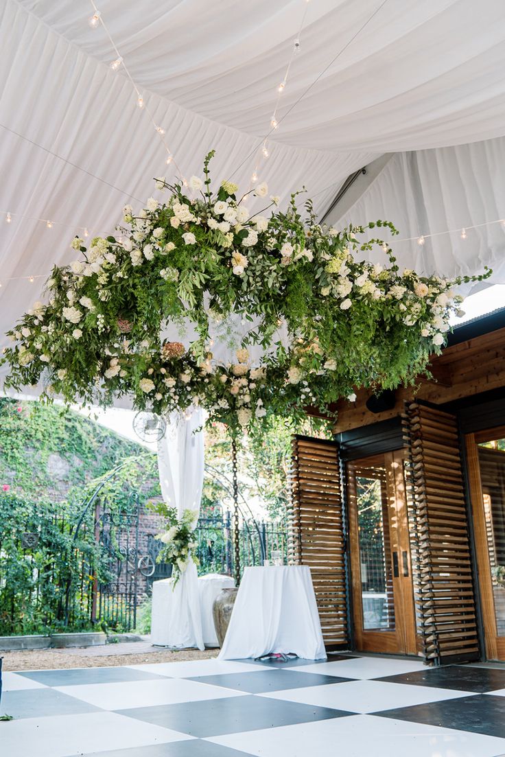 a white and black checkered floor with flowers hanging from it's centerpiece