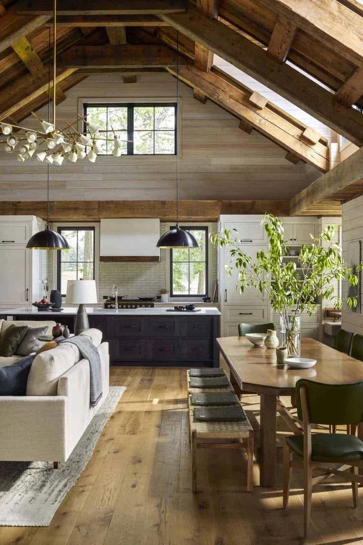 a living room filled with furniture next to a kitchen and dining room table on top of a hard wood floor