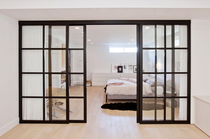 a bedroom with sliding glass doors leading to the bed