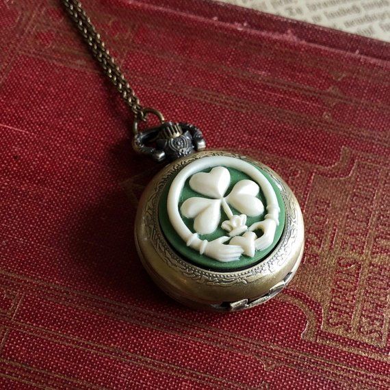 Medium 30mm pocket watch necklace with a high quality quartz movement inside.  On the front is a resin cameo of a claddagh and clover.On 28 inches of antiqued brass chain.I can make this chain any length for no extra charge. Just leave me a note at checkout!You can adjust the time by pulling up the knob and turning.Pressing the knob opens the watch.Each watch comes with a spare battery and printed care instructions. Vintage Good Luck Locket Jewelry, Day Light Savings, Easter Bookmarks, Antique Vanity Set, Oc Creator, Pocket Watch Necklace, Christmas Gifts For Girlfriend, Jewelry Watch, Vintage Style Jewellery