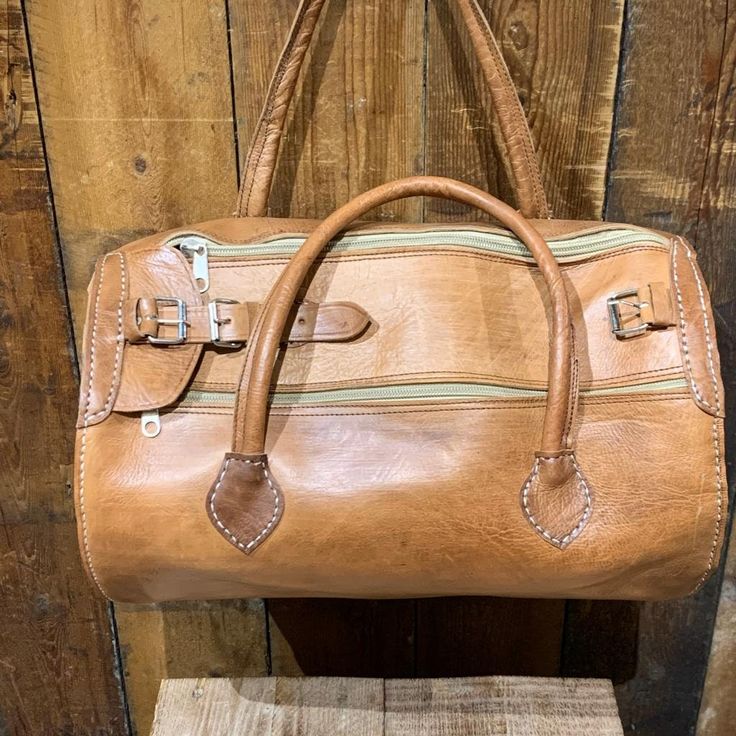 "Material : 100% Real Leather     Height : 14\"(36cm) / Width : 19\"(48cm) / Depth : 8.5\"(21cm) / Weight: 1kg  approximately, This medium tunnel shape bag is handmade of 100% real veg tan leather. Well-known weekend bag. It also used as a gym bag because of its capacity. Hand luggage for a short break or work. This superb travel bag made of several components;     1 large compartment     Top zip closure     2 side pockets     Brass buckles Adjustable leather straps and fully lined This bag has Leather Gym Bag, Sac Week End, Weekend Bag, Hand Luggage, Veg Tan Leather, Travel Duffel, Duffel Bag Travel, Brass Buckle, Overnight Bag