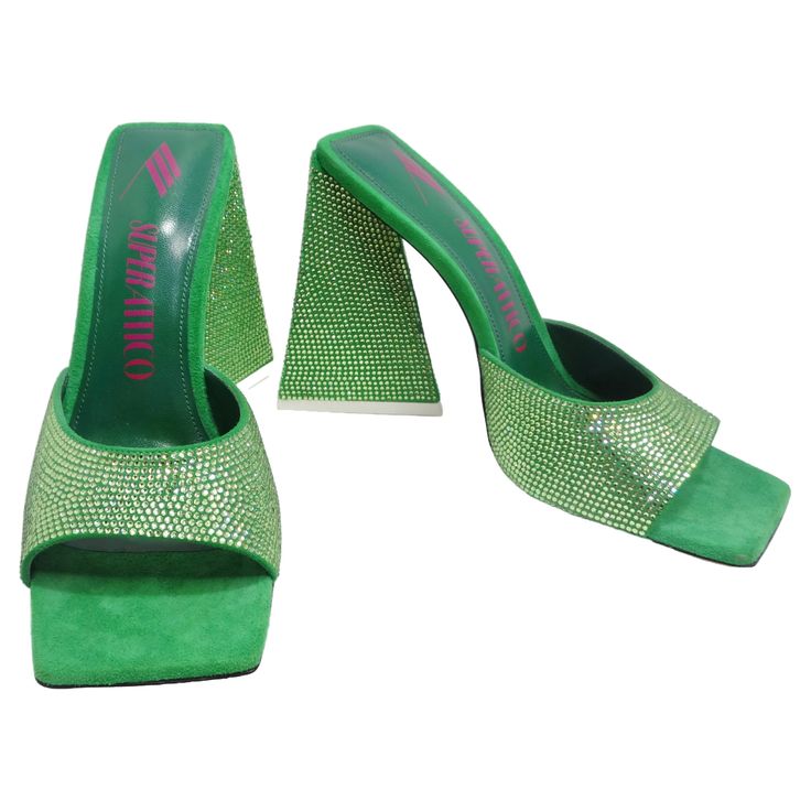 Step into sophistication with The Attico Green Devon Heeled Sandals—an exquisite pair of shoes that redefine glamour with every step. These green suede heeled mules are not just shoes; they're a dazzling display of craftsmanship and style. Picture yourself in these heeled sandals with tonal crystal cut detailing throughout. The open square toe adds a modern touch, while the printed logo in pink at the padded buffed goatskin footbed provides a subtle nod to the brand's identity. The leather outso Jean Paul Gaultier Dress, Saint Laurent Handbags, The Attico, Chanel Earrings, Heeled Sandal, Green Suede, Suede Heels, Jean Paul Gaultier, Heeled Sandals