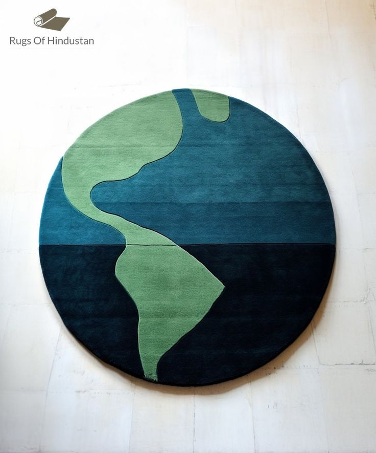 a round rug with an abstract design in blue, green and black on the floor