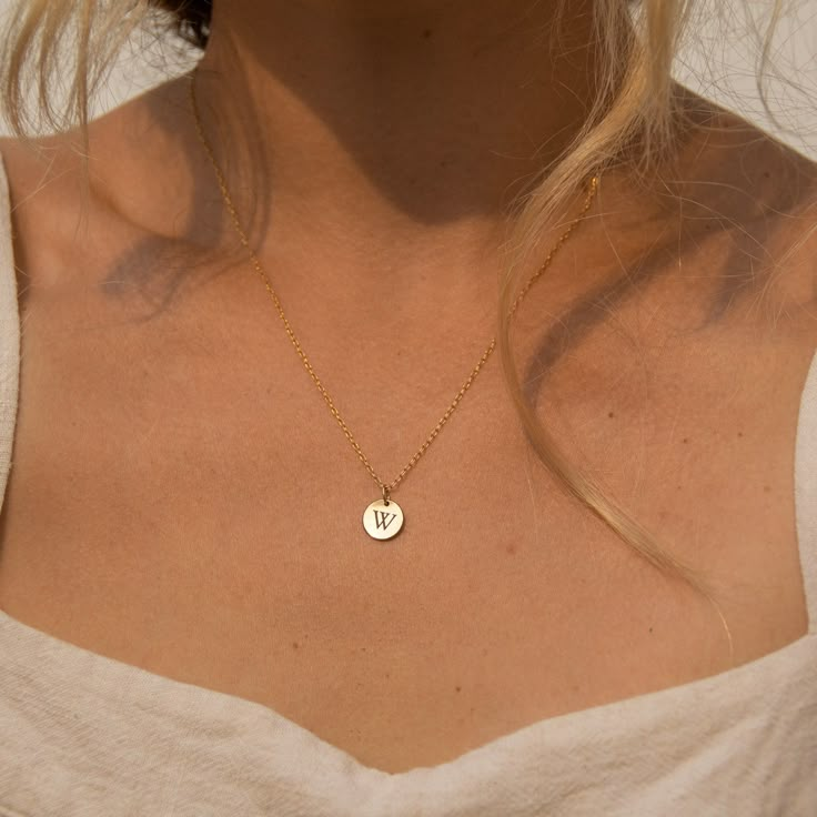 "Our tiny circle initial necklace is a fun choice when you want to make a simple, discreet statement of any single letter, number, or character that you feel defines you the best. Made of 14K gold-filled, the shiny finish disc comes on a dainty and delicate chain, giving you a truly minimalist look. Free Engraving for a limited time! NECKLACE DETAILS ⚬ 14k gold-filled disc(s) and chain. ⚬ Disc measures 10mm (.39\"). ⚬ Chain in your choice of 16\", 18\", or 20\" length ⚬ Personalized engraving of Circle Initial Necklace, Meaningful Necklaces For Girlfriends, Tiny Initial Necklace, Gold J Necklace, Minimalist Tiny Charm Necklaces For Anniversary, Tiny Minimalist Charm Necklace For Anniversary, Minimalist Tiny Charm Necklace For Anniversary, Minimalist Round Pendant Charm Necklace For Anniversary, Minimalist Name Necklace With Round Pendant And Delicate Chain