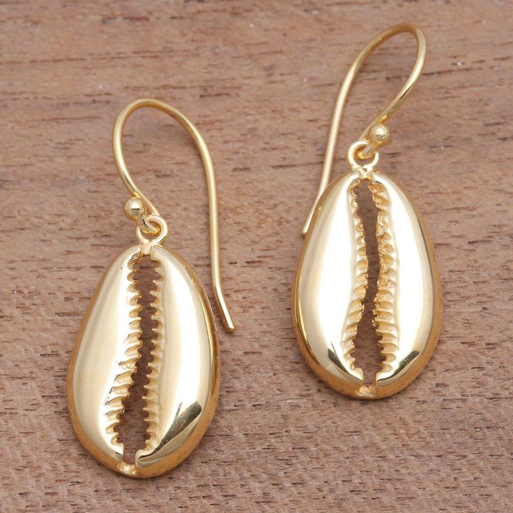 Gleaming in the light two gleaming crab claws are crafted from sterling silver bathed in 18k gold. Balinese artisan Ari Gunawan creates this pair of dangle earrings adding a nautical touch to any wardrobe. Gold Shell-shaped Brass Earrings, Gold Brass Shell-shaped Earrings, Elegant Shell-shaped Brass Jewelry, Gold Shell-shaped Jewelry With Matching Earrings, Yellow Gold Shell-shaped Earrings, Yellow Gold Shell-shaped Earrings For Pierced Ears, Handmade Oval Jewelry For Beach, Gold Brass Shell Earrings, Shell-shaped Yellow Gold Earrings Gift