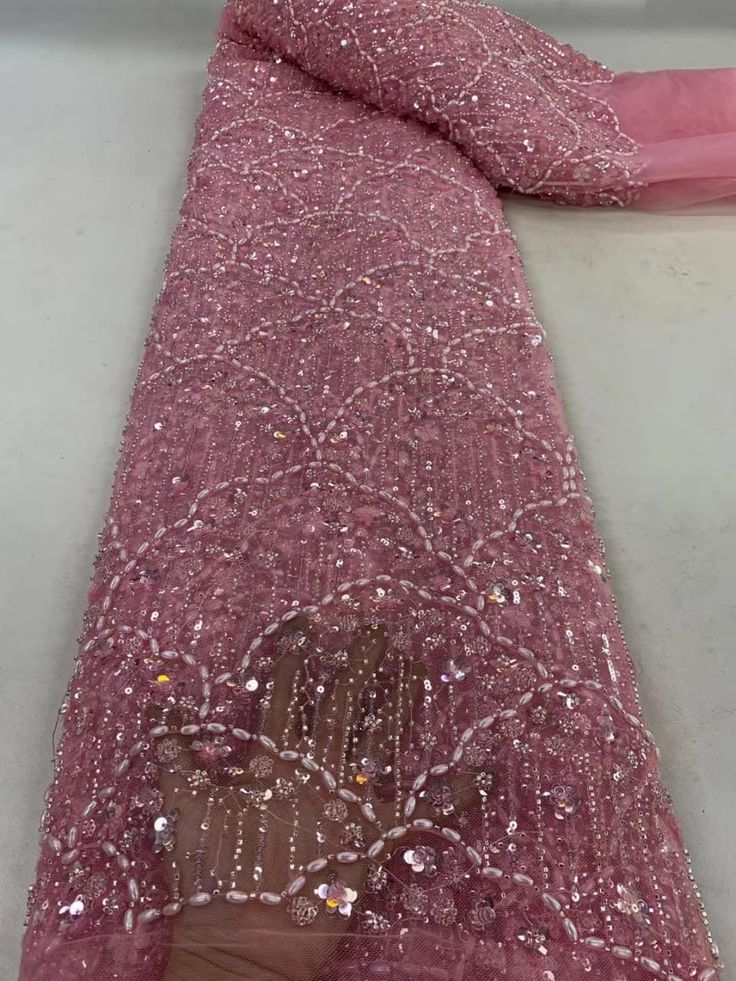 pink sequined fabric with white beads on it