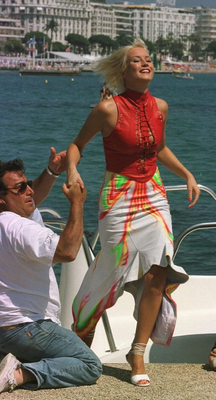 a man kneeling down next to a woman on a boat