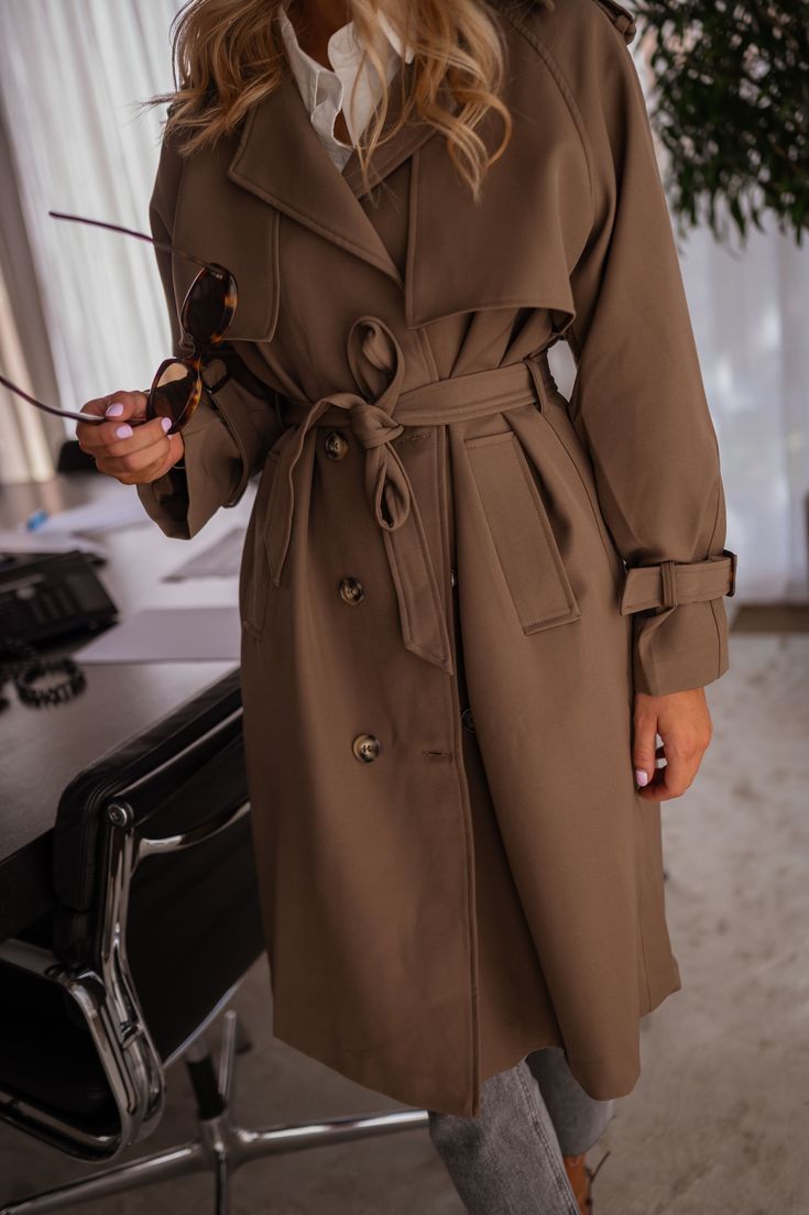 Indulge in luxury with the Chocolate Haron Trench Coat. This coat features long sleeves, a belt for a flattering fit, side pockets for functionality, and a lapel in the back with buttons for added style. The button tab and slightly thick fabrics elevate the look, while the cuffs can be tightened for a customizable fit. Stay warm and stylish with this lined trench coat. Our models are also wearing the Light Grey Julien Jeans, the White Jane T-Shirt, and the Black Jama Bag Sizes: S-M / M-L S-M: Le Elegant Coats, Thick Fabric, Stay Warm, Trench Coat, Light Grey, Long Sleeves, Models, Grey, Long Sleeve