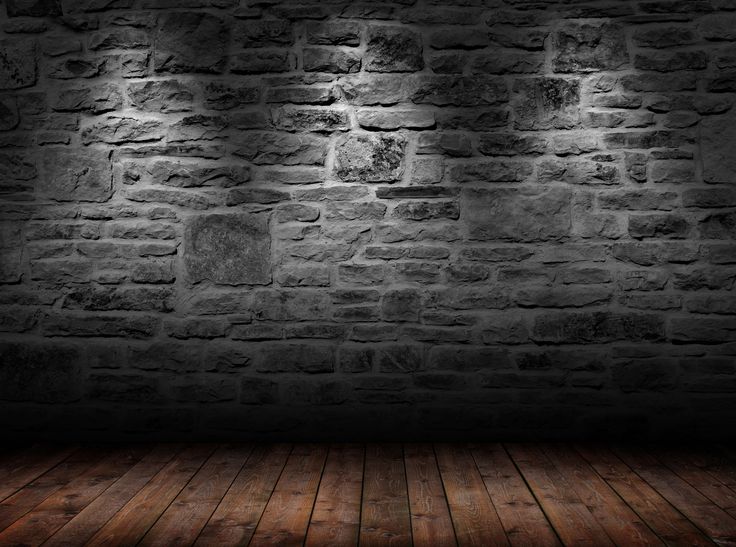 an empty room with brick walls and wooden floors, lit by lights from the ceiling