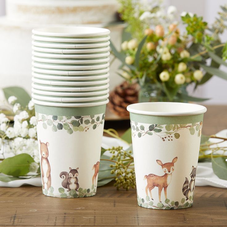 there are many cups on the table with deers and flowers around them in front of each other