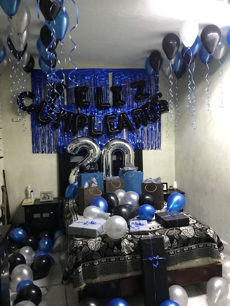 a bedroom decorated with balloons and streamers in blue, silver and black colors for a 21st birthday party