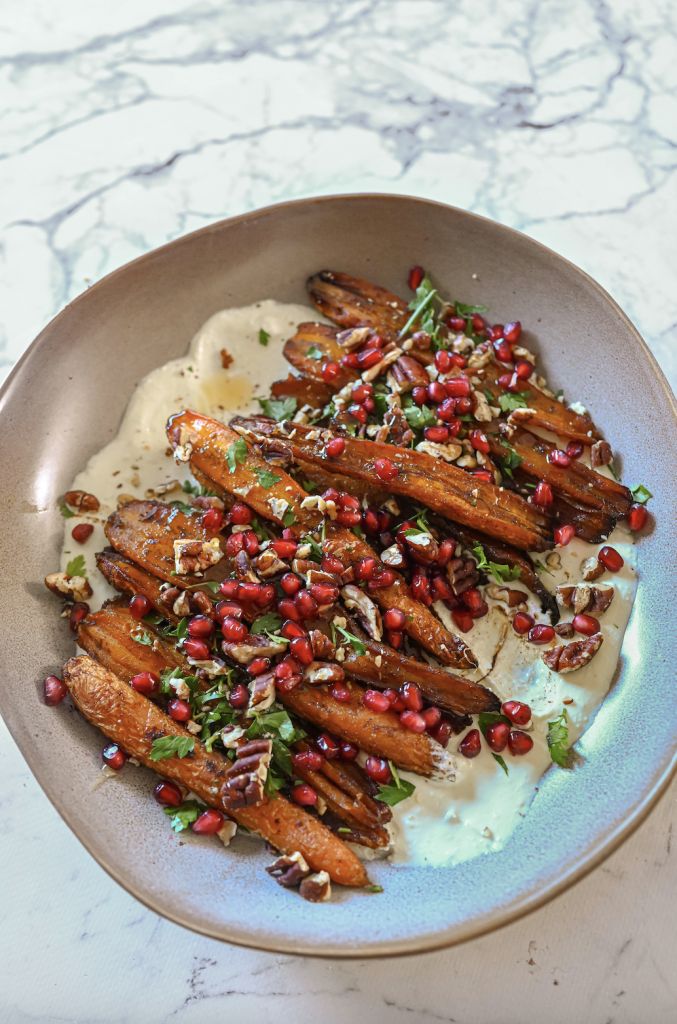 carrots with pomegranate and herbs in a bowl