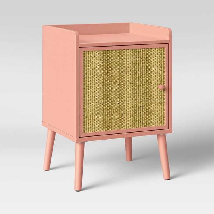 a pink and yellow cabinet sitting on top of a wooden table