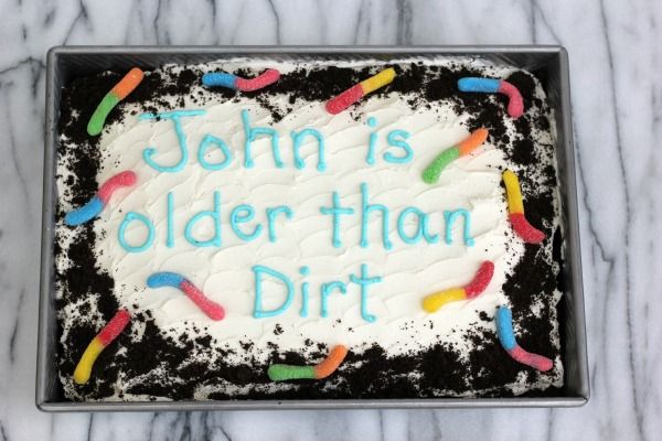 a birthday cake with white frosting and colorful sprinkles on it that says, john is older than dirt