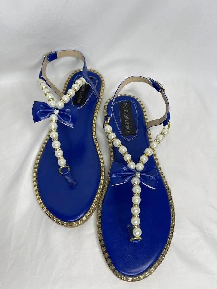 Pearl Faux Embellished T-Strap Sandals which come in a variety of colors: Blue, Red, Yellow, and Black. The sizes are 8 up to 12 US women. Blue Toe Post Sandals For Party, Blue Toe Post Party Sandals, Blue T-strap Sandals For Summer, Summer Blue Flat T-strap Sandals, Blue Flat T-strap Sandals For Summer, Blue T-strap Sandals For Vacation, Blue Adjustable T-strap Sandals, Blue T-strap Sandals For Beach, Embellished Sandals