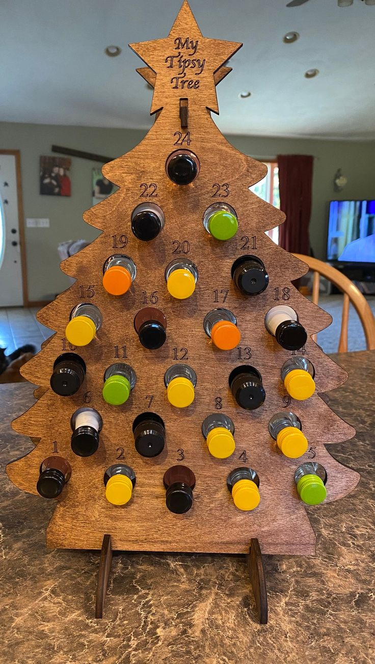 a wooden christmas tree with wine bottles on it's top and the words, my happy new year