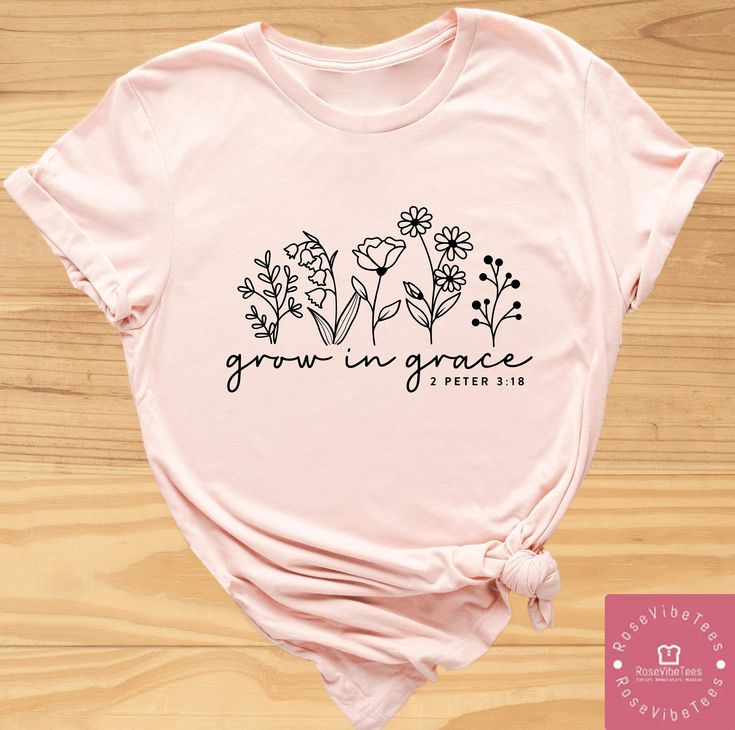 a pink t - shirt with flowers and the words grow in grace on it