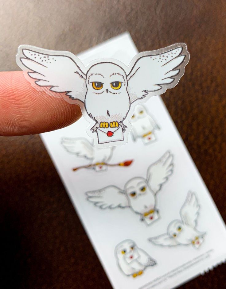 Sheet of Harry Potter stickers featuring illustrations of Hedwig, shown on a white background. One sticker is shown removed from sheet and attached to an index finger to show detail. Harry Potter Clip Art, Gryffindor Harry Potter, Harry Potter Activities, House Stickers, Gift Me, Harry Potter Owl, Harry Potter Stickers, Cute Harry Potter, Harry Potter Food